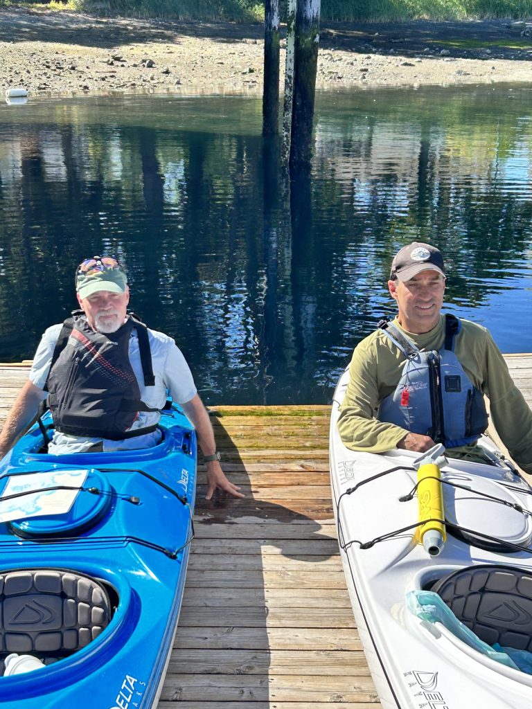 Listening intently to instructions for tandem ocean kayaking. The rear position is responsible for steering.