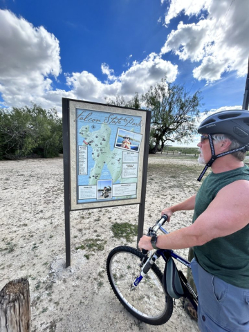 Curtis checks out the map while cycling around Falcon State Park, Texas.