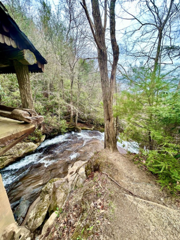 The river becomes a waterfall shortly after passing under an old covered shelter.