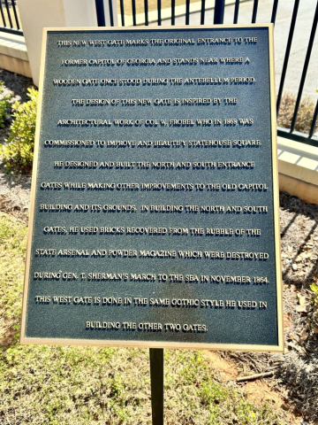 A plaque explains that the gates to the Capitol were part of a beautification project at the Statehouse Square.